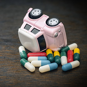 Overturned toy car on a pile of pills for California prescription medication DUI defense.