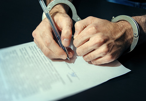 Close-up of hands in metal handcuffs during a domestic violence police arrest.